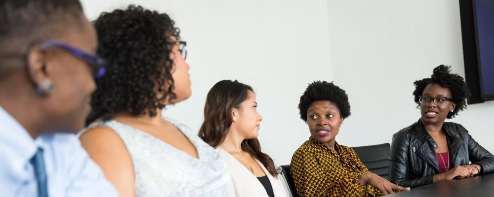 Colleagues in discussion around a conference table, one speaking