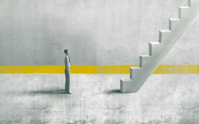 A lone figure at the foot of a staircase