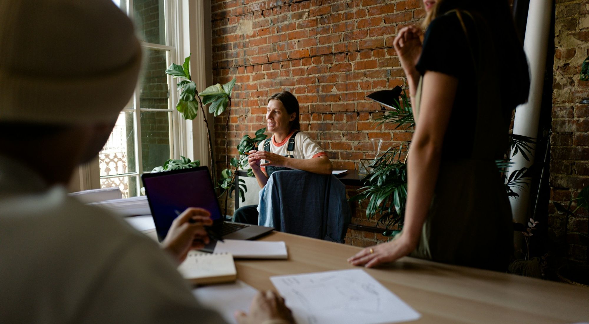 Colleagues around a meeting table, seen past a person in the foreground