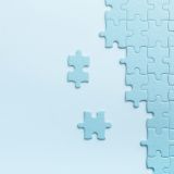 Two loose jigsaw pieces beside an assembled puzzle