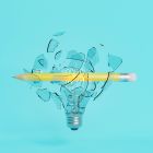 A pencil breaking through a glass lightbulb