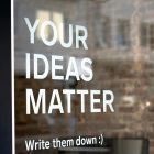 A sign reading "Your ideas matter — write them down"