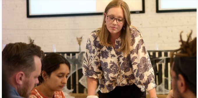 A facilitator leading a working session with a small group around a table