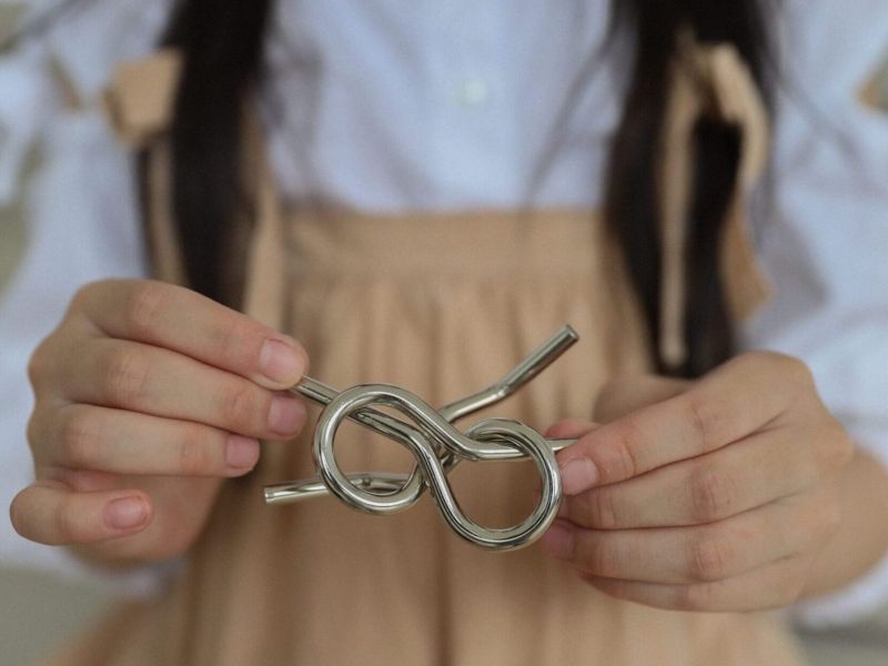 A girl holding a loose metal knot